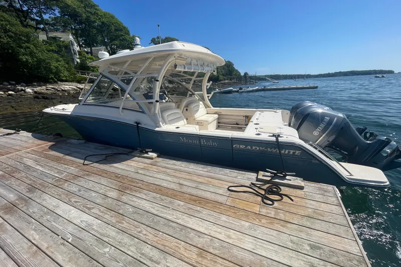 Slide: The Image of 2021 Grady-White Freedom 325 boat docked by a scenic waterfront. - 1