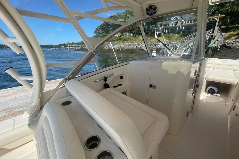 Slide: The Image of 2021 Grady-White Freedom 325 boat interior with seating, docked by a scenic waterfront. - 12
