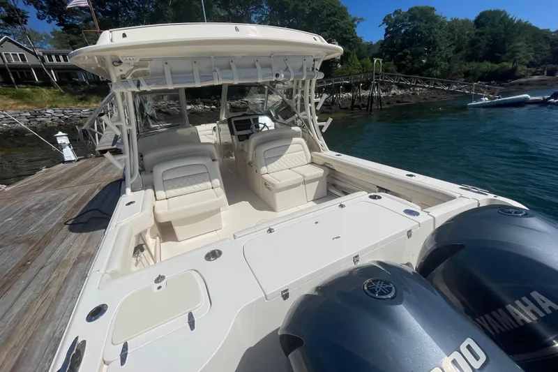 Slide: The Image of 2021 Grady-White Freedom 325 boat docked, featuring dual Yamaha engines and spacious seating. - 23