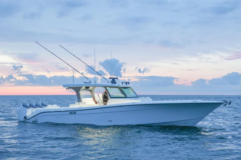 Slide: The Image of 2027 HCB 48 Campeon boat on ocean at sunset, showcasing sleek design and powerful engines. - 5