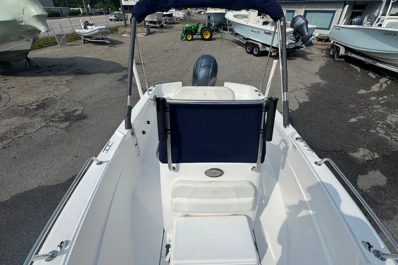 Slide: The Image of 2020 Edgewater 170CC boat interior with seating and motor, parked in a marina. - 7