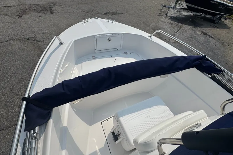 Slide: The Image of 2020 Edgewater 170CC boat interior with seating and storage, docked on pavement. - 5