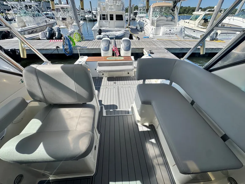 Slide: The Image of The image shows the cockpit of a 2006 Pursuit 3370 Offshore. It features gray seating and is docked at a marina. - 11