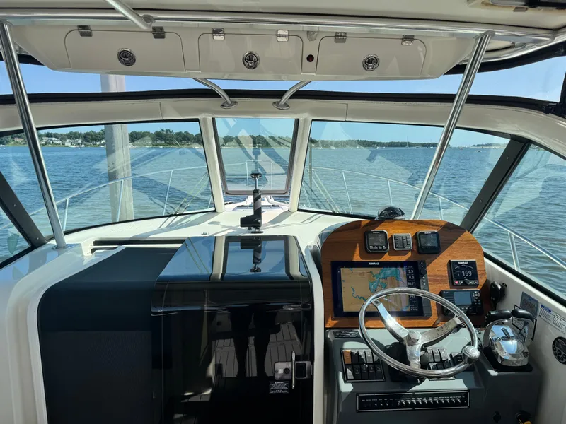 Slide: The Image of The cockpit of a 2006 Pursuit 3370 Offshore with modern navigation electronics and a wooden dashboard. - 10