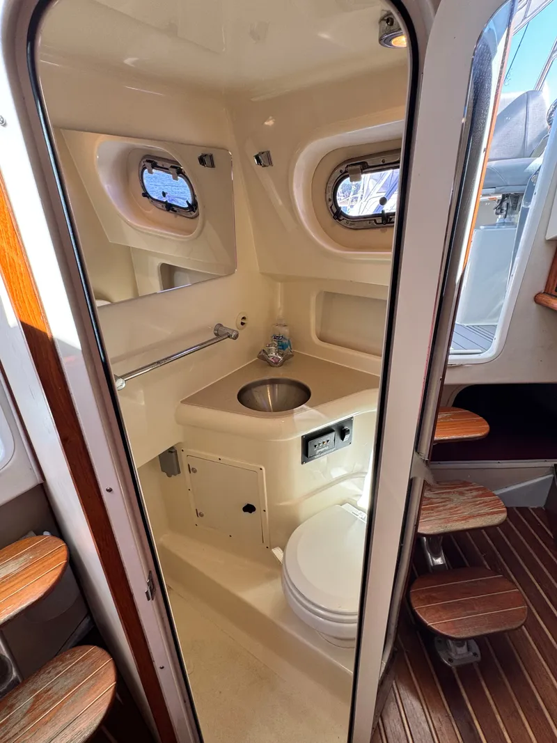 Slide: The Image of The image shows the bathroom of a 2006 Pursuit 3370 Offshore with a sink and toilet. - 24