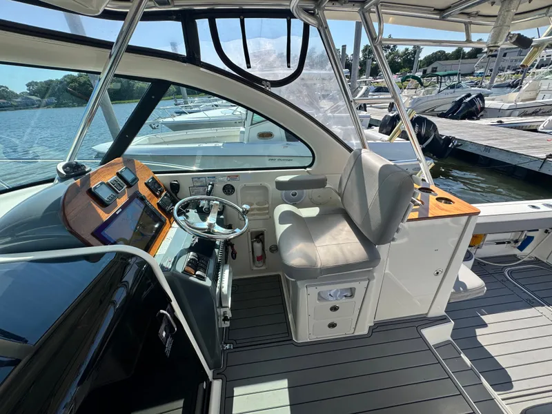 Slide: The Image of The cockpit of a 2006 Pursuit 3370 Offshore with a modern helm and comfortable seating. - 13
