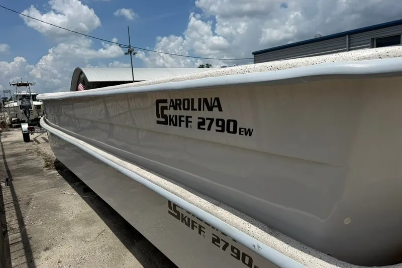 Slide: The Image of 2027 Carolina Skiff 2790 boat docked under a cloudy sky. - 10