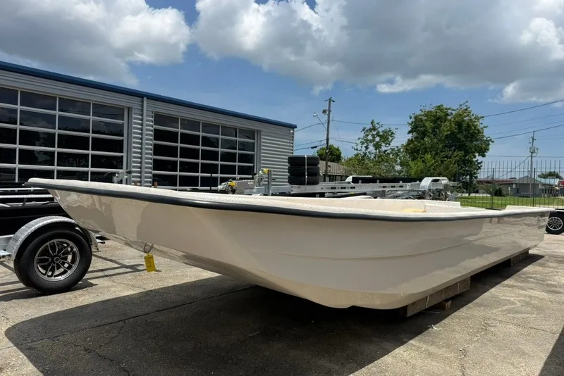 Slide: The Image of 2027 Carolina Skiff 2790 boat displayed outdoors near a garage under a cloudy sky. - 5