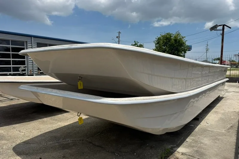 Slide: The Image of 2027 Carolina Skiff 2790 boat hulls stacked outdoors under cloudy sky. - 12
