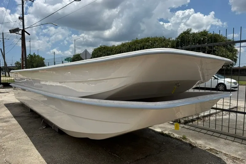 Slide: The Image of 2027 Carolina Skiff 2790 boat hulls stacked outdoors under a cloudy sky. - 3