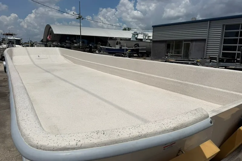 Slide: The Image of 2027 Carolina Skiff 2790 boat hull in a marina setting under a cloudy sky. - 9