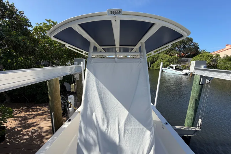 Slide: The Image of 2015 Ranger boat with canopy docked by a serene waterfront. - 12
