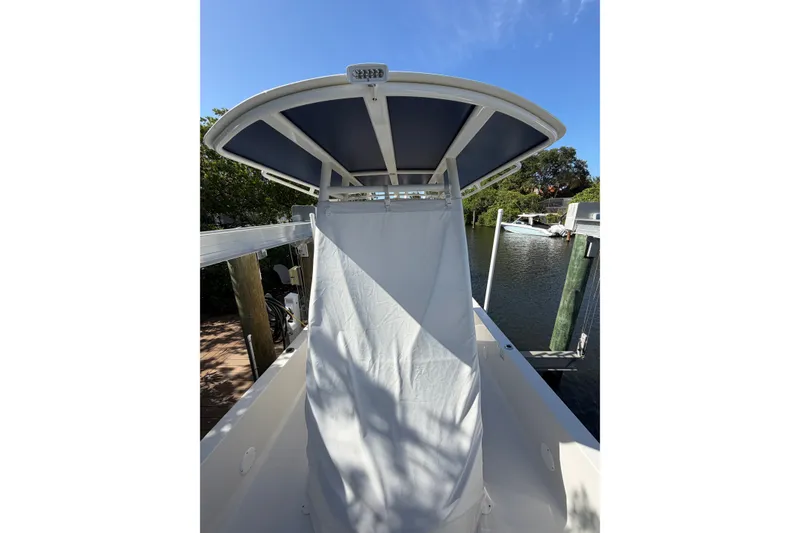 Slide: The Image of 2015 Ranger boat with T-top canopy, docked by a serene waterfront. - 13