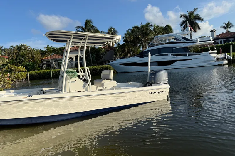Slide: The Image of 2015 Ranger boat on calm water, with luxury yacht and palm trees in the background. - 6