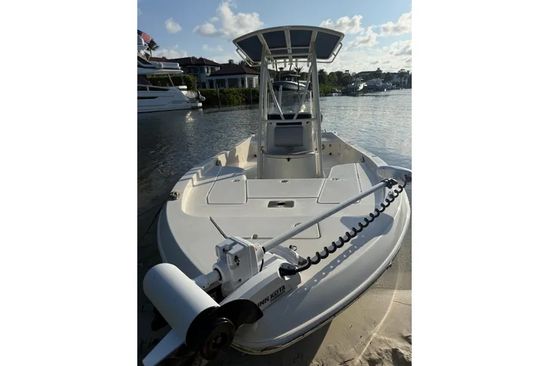 Slide: The Image of 2015 Ranger boat docked by waterfront homes under a clear sky. - 2