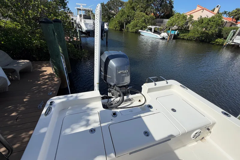 Slide: The Image of Boat docked by waterfront with Yamaha 250 engine, surrounded by greenery and residential area. - 10