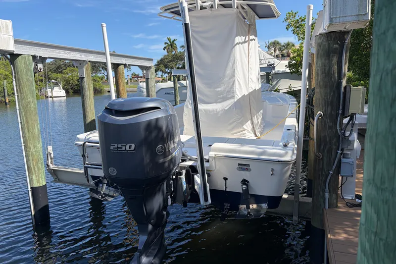 Slide: The Image of Boat with Yamaha 250 engine docked on a lift, surrounded by water and greenery. - 15