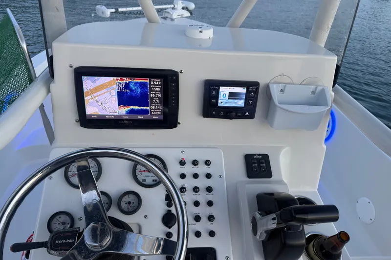 Slide: The Image of Boat dashboard with Garmin navigation system, steering wheel, and control panel on a Ranger 2015 model. - 27