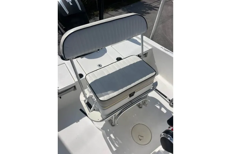 Slide: The Image of 2016 Mako 19 CPX boat seat with white cushioned backrest and storage compartment. - 6