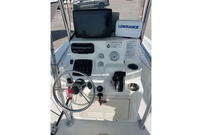 Slide: The Image of Center console of a 2016 Mako 19 CPX boat with steering wheel and navigation equipment. - 4