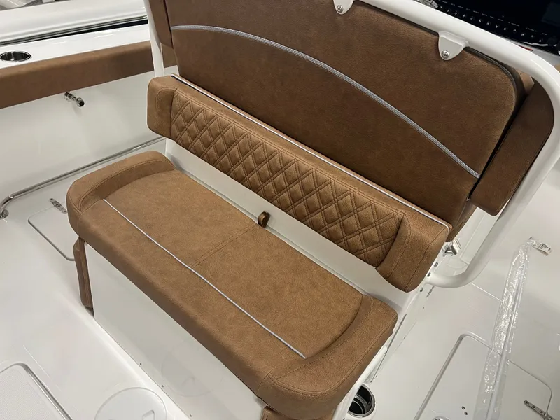 Slide: The Image of The 2027 Sea Hunt Ultra 265 SE features a brown upholstered bench seat with a quilted pattern. - 13