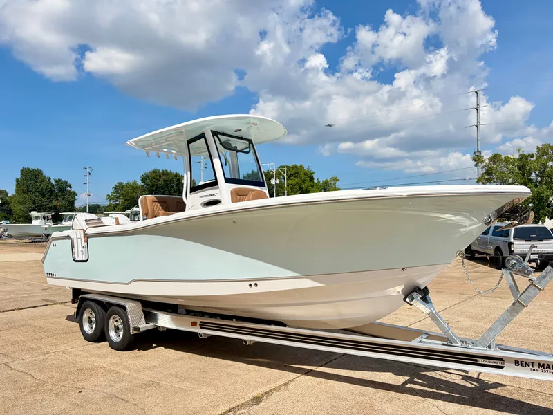 Slide: The Image of A 2027 Sea Hunt Ultra 265 SE boat on a trailer. It features a modern design with a T-top. - 3