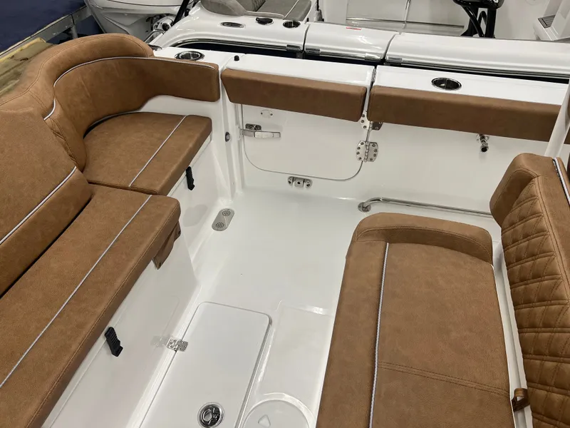 Slide: The Image of Interior view of a Sea Hunt Ultra 265 SE boat with brown upholstered seats and white flooring. - 14