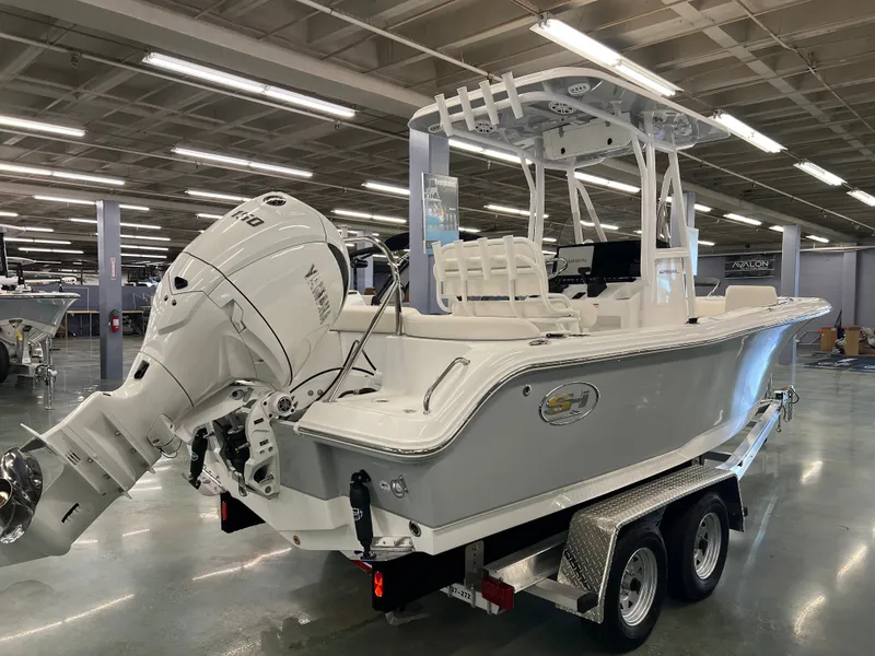 Slide: The Image of A 2027 Sea Hunt Ultra 219 boat on a trailer in a showroom. - 5
