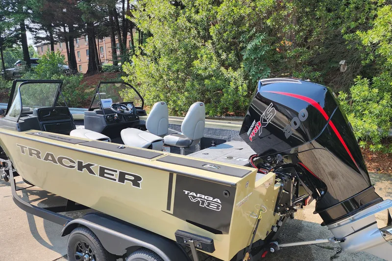 The Image of 2027 Tracker Targa V-18 Combo boat with powerful outboard motor, parked outdoors. - 1