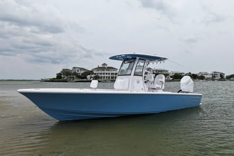 The Image of 2027 Sportsman Masters 267 Bay Boat in calm waters near coastal homes. - 0