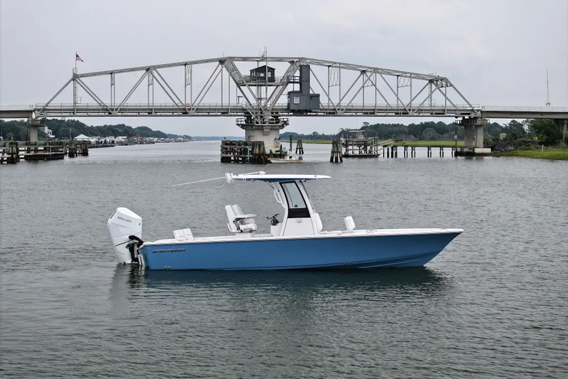 Slide: The Image of 2027 Sportsman Masters 267 Bay Boat on water near a bridge, showcasing sleek design. - 9