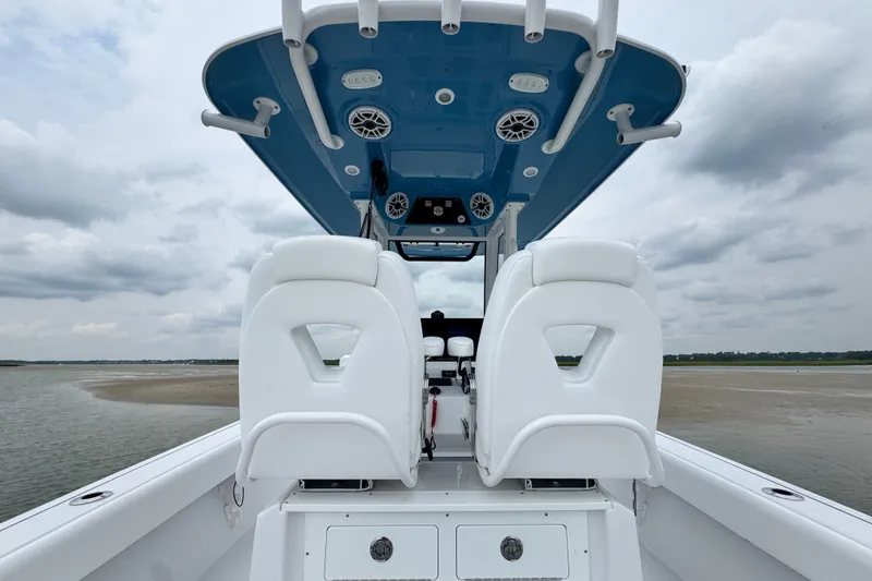Slide: The Image of 2027 Sportsman Masters 267 Bay Boat interior with white seating and blue canopy. - 21