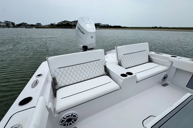 Slide: The Image of 2027 Sportsman Masters 267 Bay Boat with white seating and Mercury engine on calm water. - 22