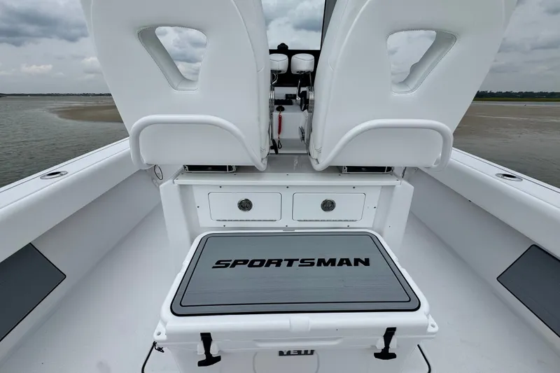 Slide: The Image of 2027 Sportsman Masters 267 Bay Boat interior with white seating and storage compartments. - 20