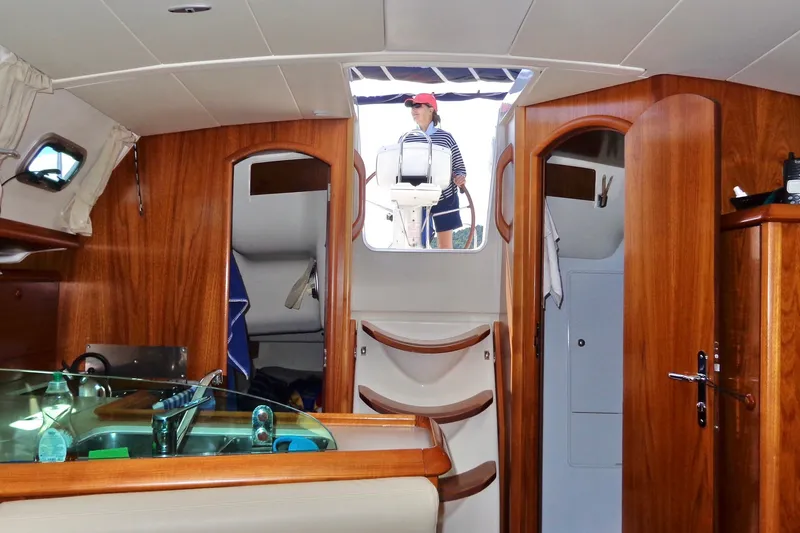 Slide: The Image of Interior of 2004 Jeanneau Sun Odyssey 37 sailboat with wooden finish and person at helm. - 23