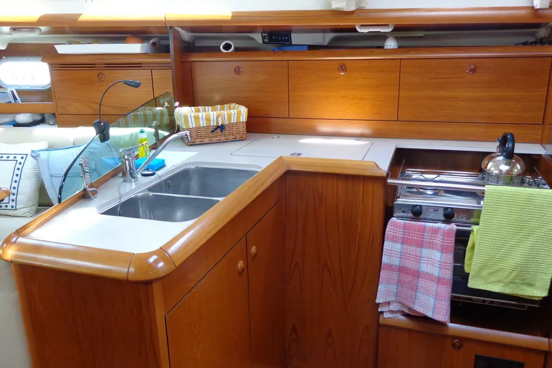 Slide: The Image of Interior of 2004 Jeanneau Sun Odyssey 37 yacht kitchen with wooden cabinetry and stainless steel sink. - 19