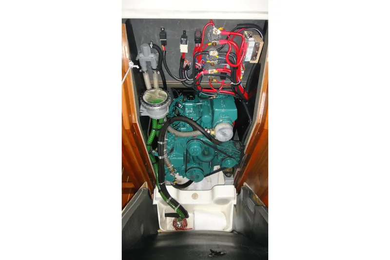 Slide: The Image of The engine compartment of a 2004 Jeanneau Sun Odyssey 37 features a green engine with wiring. - 27