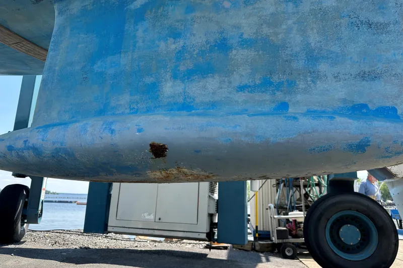 Slide: The Image of 2004 Jeanneau Sun Odyssey 37 keel with visible rust spot, dockside maintenance setting. - 34