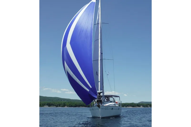 Slide: The Image of 2004 Jeanneau Sun Odyssey 37 sailboat with blue spinnaker on open water. - 8