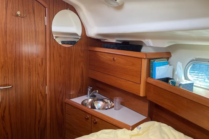 Slide: The Image of Interior of 2004 Jeanneau Sun Odyssey 37 yacht with wooden cabinetry and round mirror. - 21