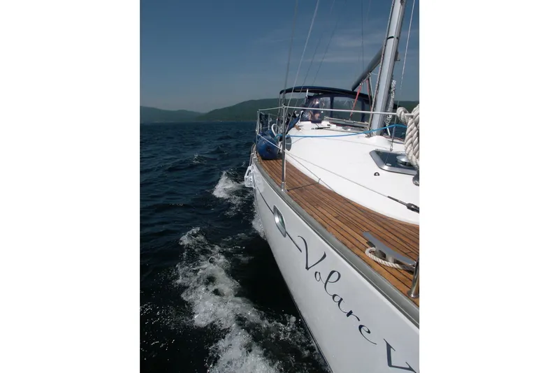 Slide: The Image of 2004 Jeanneau Sun Odyssey 37 sailing on open water, showcasing sleek design and wooden deck. - 2