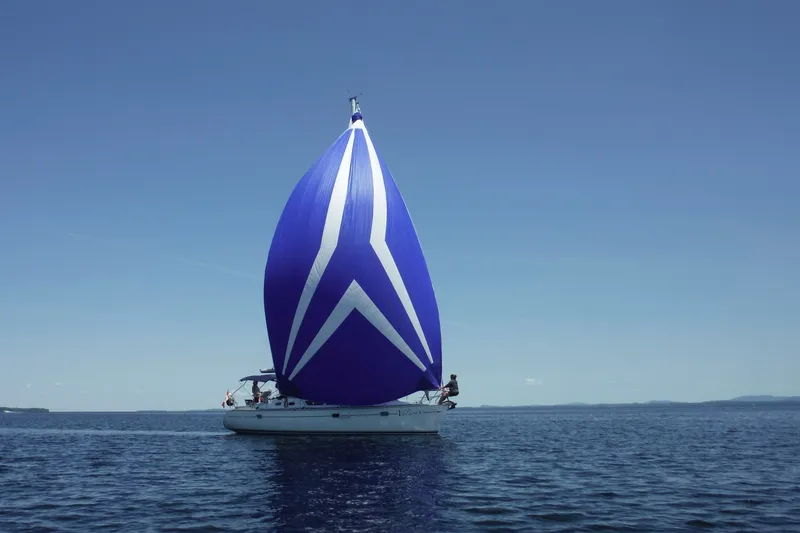Slide: The Image of 2004 Jeanneau Sun Odyssey 37 sailing with a vibrant blue spinnaker on open water. - 7