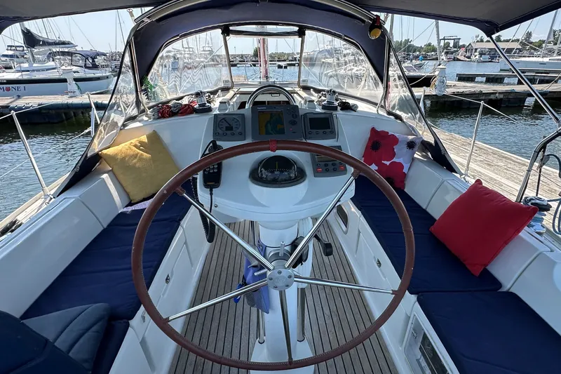 Slide: The Image of Cockpit of a 2004 Jeanneau Sun Odyssey 37 sailboat with cushions and navigation equipment. - 13