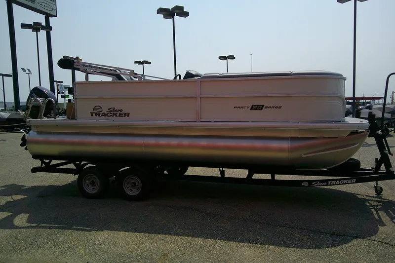 Slide: The Image of 2026 Sun Tracker Party Barge 20 DLX pontoon boat on trailer in parking lot. - 87