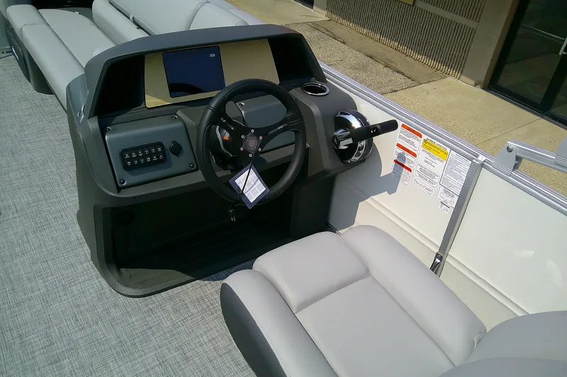 Slide: The Image of 2026 Sun Tracker Party Barge 20 DLX helm with steering wheel and controls. - 95