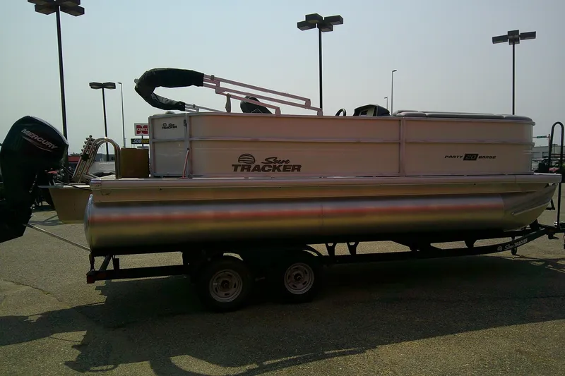 Slide: The Image of 2026 Sun Tracker Party Barge 20 DLX pontoon boat on trailer in parking lot. - 85