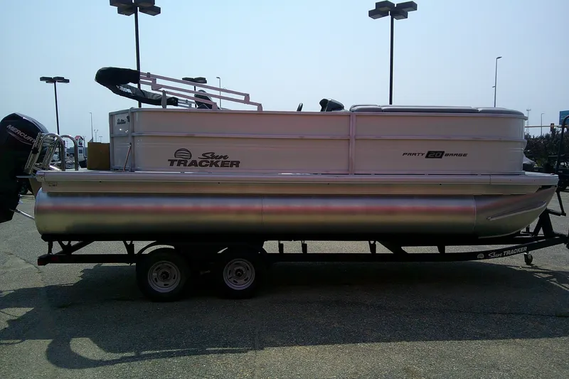 Slide: The Image of 2026 Sun Tracker Party Barge 20 DLX pontoon boat on trailer in parking lot. - 86