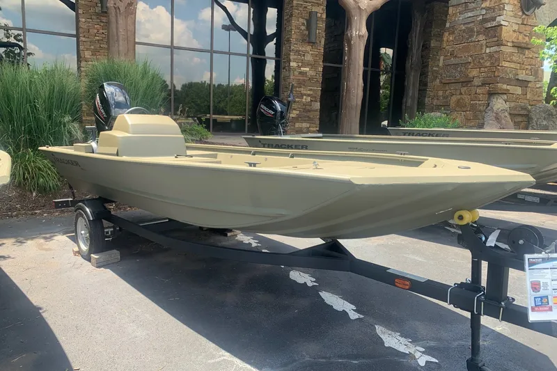 The Image of 2026 Tracker Grizzly 1648 SC boat on trailer, displayed outdoors near a building. - 0
