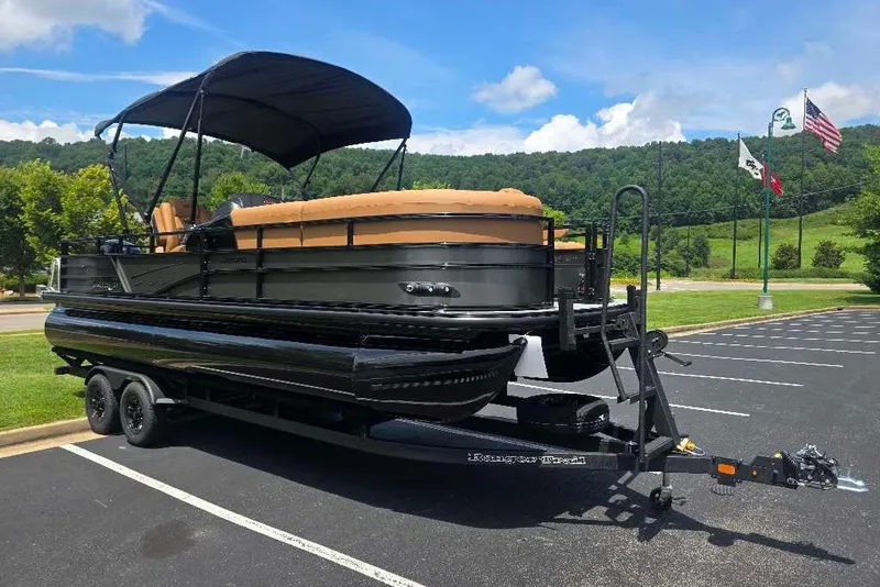 Slide: The Image of 2026 Ranger 220FC pontoon boat on trailer in parking lot, scenic background. - 1
