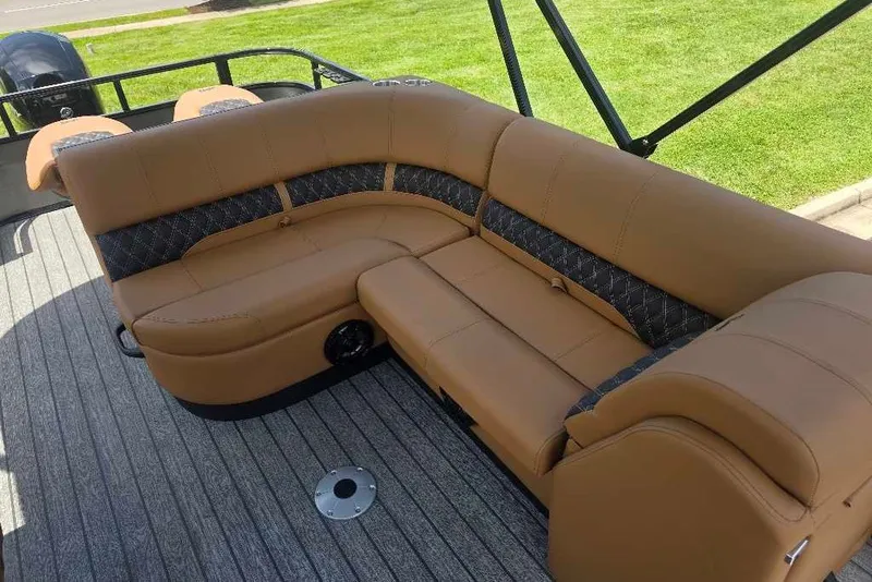 Slide: The Image of 2026 Ranger 220FC boat interior with tan and black seating on gray flooring. - 9